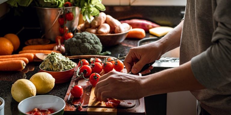 Person Cutting Up Tomatoes As Part Of A Healthy Diet.jpg