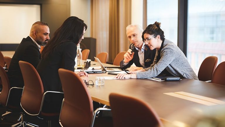 Male And Female Lawyers Discussing Over Document At Conference Table In Mee.jpg