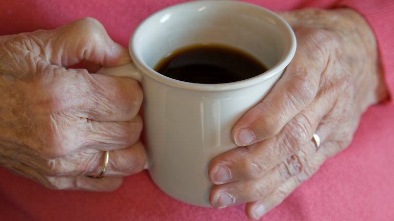 Elderly Womans Hands Holding Coffee Cup.jpg